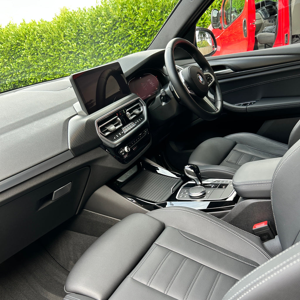 Close-up of a car's interior with gray seats and control panel.